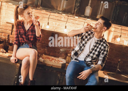 Couple don't cooking. Enjoy and eating buy pizza. Indoor, kitchen home interior, studio shot. Stock Photo