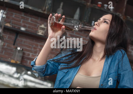 Young female alcoholic social problems sitting at table drinking beer addictive Stock Photo