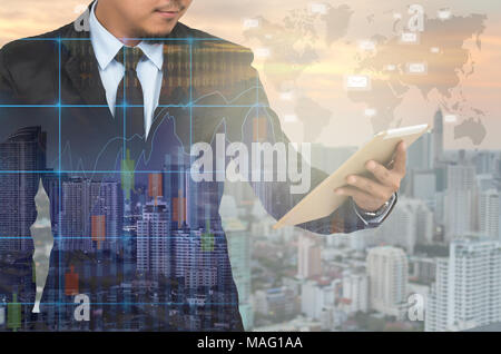 Double exposure of businessman using the tablet with cityscape and financial graph on blurred building background, Elements of this image furnished by Stock Photo