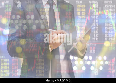Double exposure of businessman using smart tablet over the soft screen of stock market background, business trading concept Stock Photo