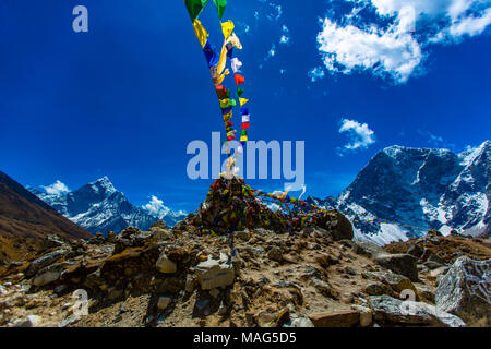 Himalayan mountain range as seen through a colourful spray of Nepali prayer flags blowing in the wind.  Himalayas, Nepal Stock Photo