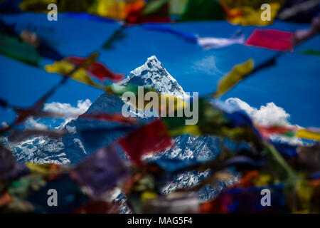 Pokhara mountain as seen through a colourful spray of Nepali prayer flags blowing in the wind.  Himalayas, Nepal Stock Photo