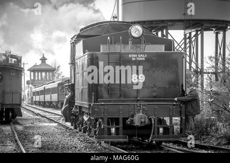 Man holding onto the back of a train car at the Strasburg Rail Road in Pennsylvania Stock Photo