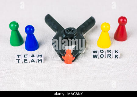 Team work concept - Figures form with clamp tool as symbol for a working labor team collaboration. Stock Photo