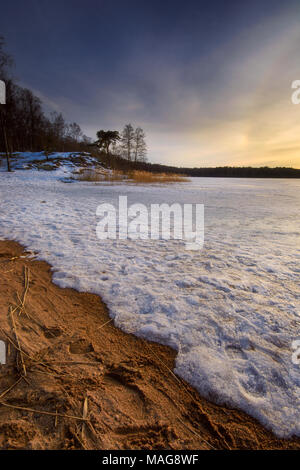 Frozen lake of Hjarlanda Tjarn in gothenburg during a fine evening with golden light from setting sun coming from west . The beast from east freezing  Stock Photo