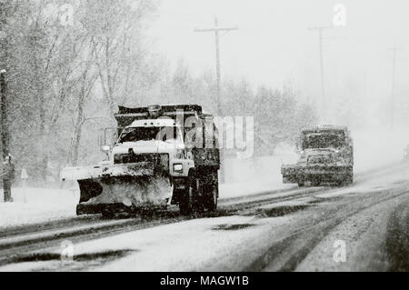 Two snow plows clearing the road in snow in black and white. Stock Photo