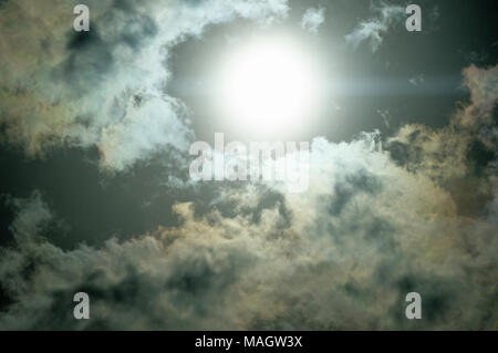 Sun dramatically shining through fluffy clouds. Stock Photo