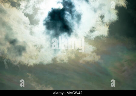 Sun dramatically shining through fluffy clouds. Stock Photo