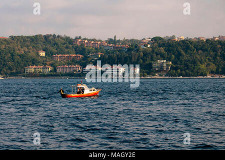 Small fishing boat on Bosphorus strait in Istanbul. Asian side is in the background. Stock Photo