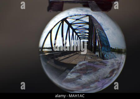A railroad steel bridge reflected in a crystal ball Stock Photo