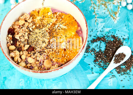 Detox and healthy superfoods breakfast bowl concept. Vegan coconut milk chia seeds pudding with granola and citrus. top view, flat lay. Stock Photo