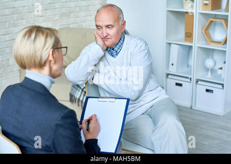 Depressed Senior Man in Therapy Session Stock Photo