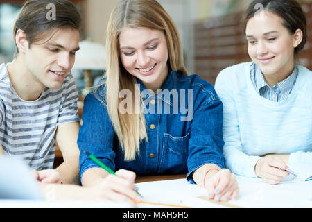 Cheerful students working and laughing Stock Photo