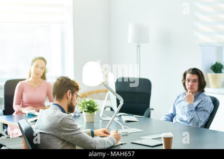 Businessman writing tasks at staff meeting Stock Photo