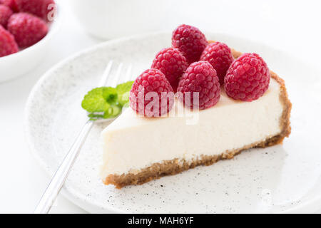 Cheesecake with fresh raspberries on white plate. Closeup view, selective focus Stock Photo