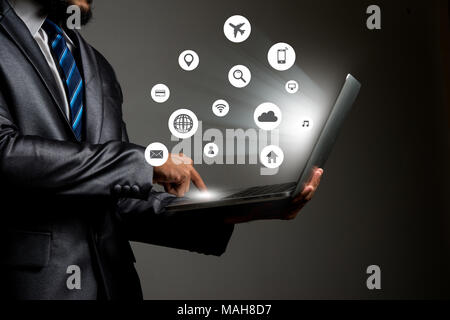 Businessman with multimedia icon interface on laptop conceptual image of social connection Stock Photo