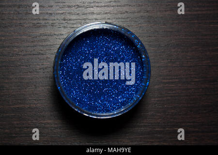 Cobalt blue glitter powder isolated on dark wooden background from a high angle view Stock Photo