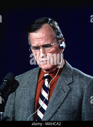 Camp Greentop, Maryland, USA, February 25, 1990 President George H.W. Bush uses an earpiece to listern to a translator during a joint news conference with Chancellor Helmut Kolh just outside Camp David Credit: Mark Reinstein/MediaPunch Stock Photo