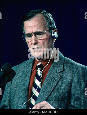 Camp Greentop, Maryland, USA, February 25, 1990 President George H.W. Bush uses an earpiece to listern to a translator during a joint news conference with Chancellor Helmut Kolh just outside Camp David Credit: Mark Reinstein/MediaPunch Stock Photo