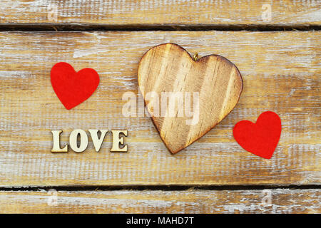 Word love written with wooden letters and hearts on rustic surface Stock Photo