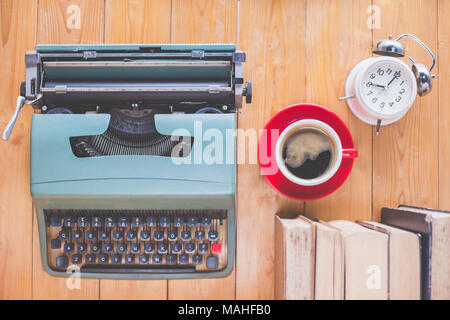 Old typewriter with a cup of coffee and books on wood table Stock Photo