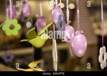 Easter holiday card with easter eggs and birds on ribbons tied to the ceiling Stock Photo