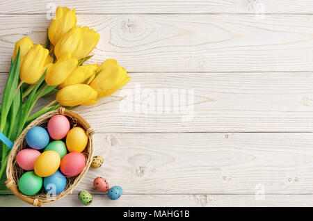 Easter background with Easter eggs and spring flowers. Top view with copy space. Stock Photo