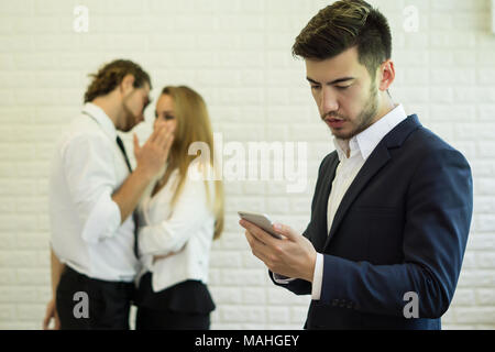 Businesswoman using smartphone while coworker interacting in the background in the office Stock Photo