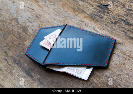 Leather holder for money and card in the shape of a coffin and key ring in bat wing shape. Stock Photo
