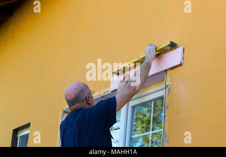 The worker measures the window. Installing a new window and finishing works around it Stock Photo