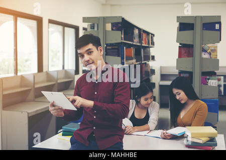 Young students doing using tablet pc at library. Stock Photo
