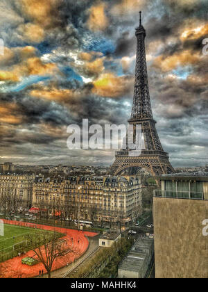 Eiffel Tower in Paris seen from a Building Behind During a Dramatic Sunset Stock Photo