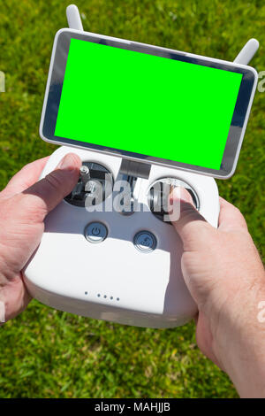Hands Holding Drone Quadcopter Controller With Blank Green Screen. Stock Photo