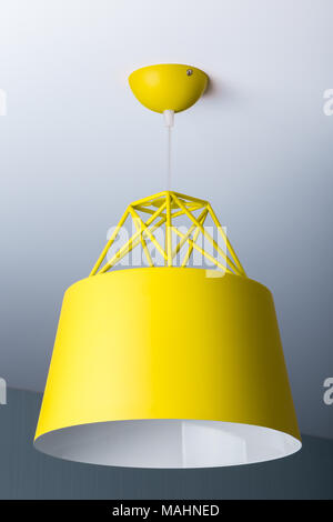 Yellow ceiling lamp in a modern minimalist style. Chandelier photographed close-up Stock Photo