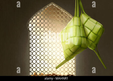 Ketupat or rice dumpling for Eid Mubarak with sunset view from windows Stock Photo