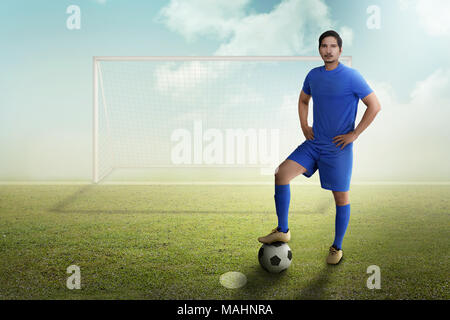 Young asian soccer player with ball on the field Stock Photo