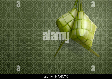 Ketupat is traditional food for eid celebration over green background Stock Photo