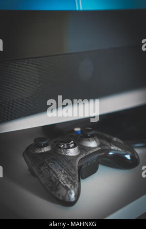 Modern gamepad lying near tv. Gaming concept. Stock Photo