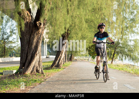 Senior Asian woman riding a bicycle Stock Photo