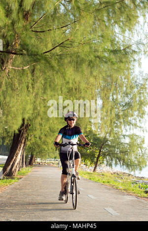 Senior Asian woman riding a bicycle Stock Photo