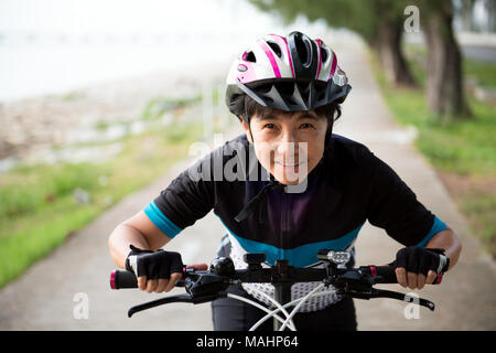 Joyful senior woman riding a bicycle Stock Photo