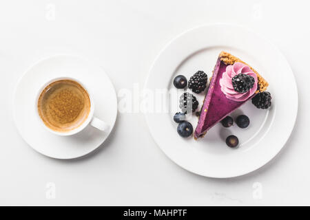 top view of piece of cake with berries and cup of coffee isolated on white tabletop Stock Photo