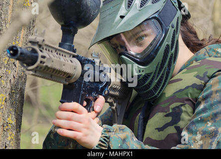 Paintball player under attack in forest Stock Photo