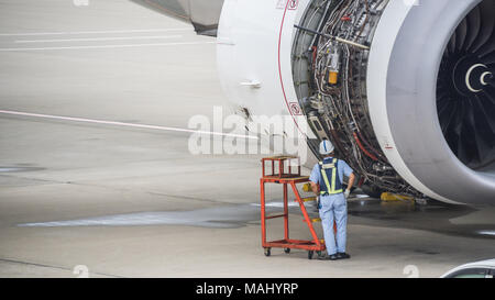 worker examining open engine compartment on jetliner Stock Photo