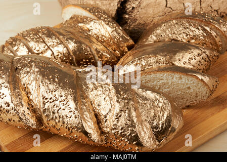 Group of gold metal bread pieces laying on wooden  table Stock Photo