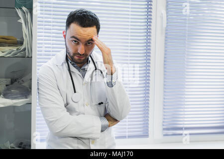A young handsome pensive man doctor at hospital ward before operation Stock Photo
