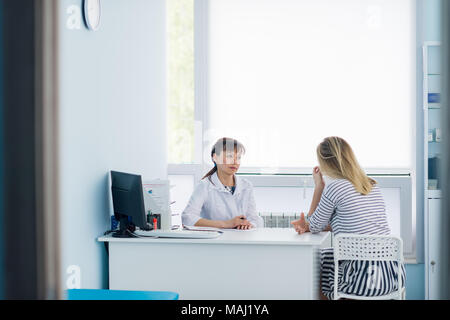 friendly female doctor comforting middle aged patient in hospital Stock Photo