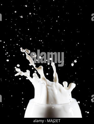 Milk/white liquid splash from glass on black background Stock Photo