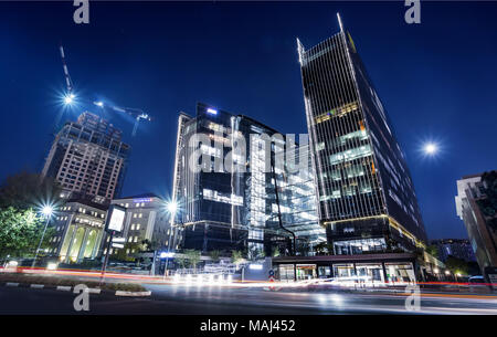 Johannesburg, South Africa, March 29-2018: Modern building at night with construction cranes in skyline. Stock Photo