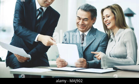 A successful business group discusses a work plan using a tablet Stock Photo